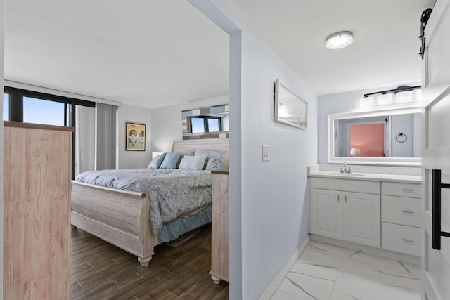 bedroom with multiple windows, sink, and light wood-type flooring