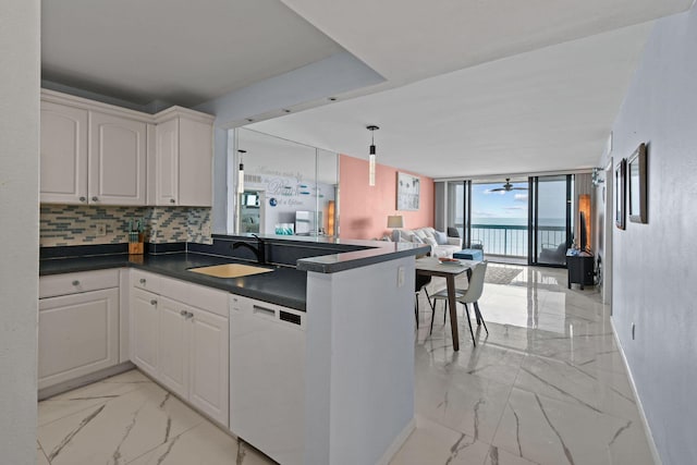 kitchen with white cabinetry, dishwasher, sink, and kitchen peninsula