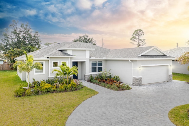 view of front of house featuring a garage and a lawn