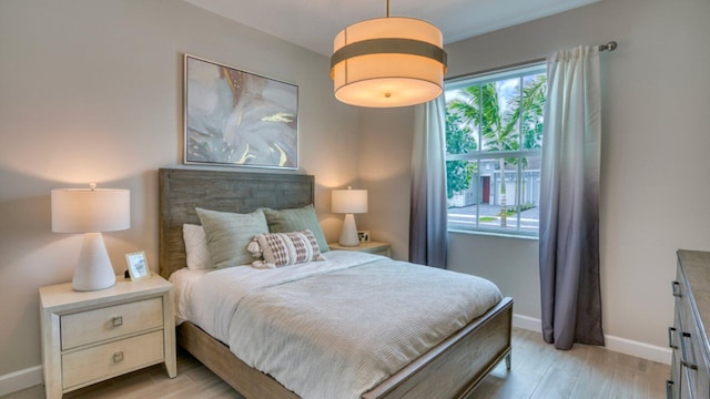 bedroom featuring light wood-type flooring and baseboards