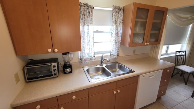 kitchen with sink, light tile patterned floors, and white dishwasher