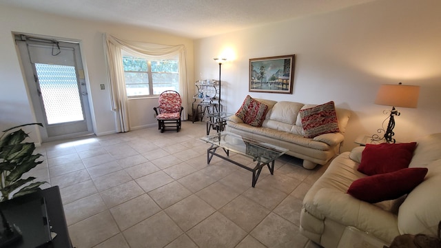 living room with a textured ceiling and light tile patterned floors