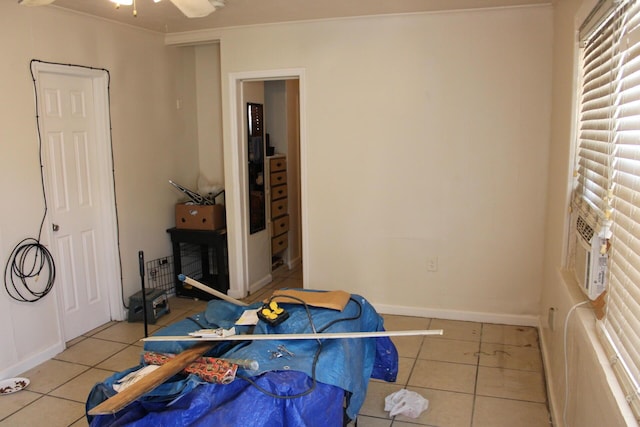 tiled bedroom with ornamental molding and ceiling fan