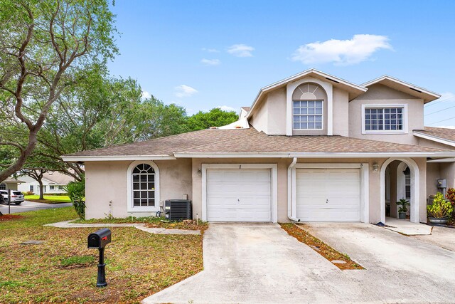 view of front facade featuring a garage, central AC, and a front yard