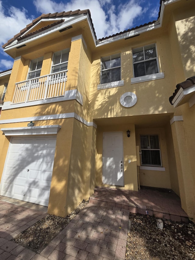 view of front of property with a garage and a balcony