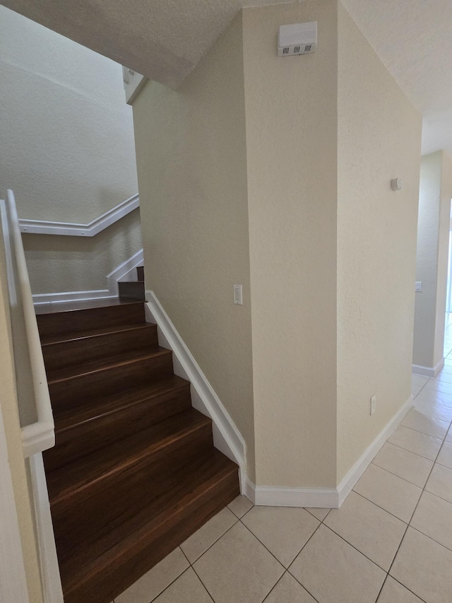 stairs featuring tile patterned flooring