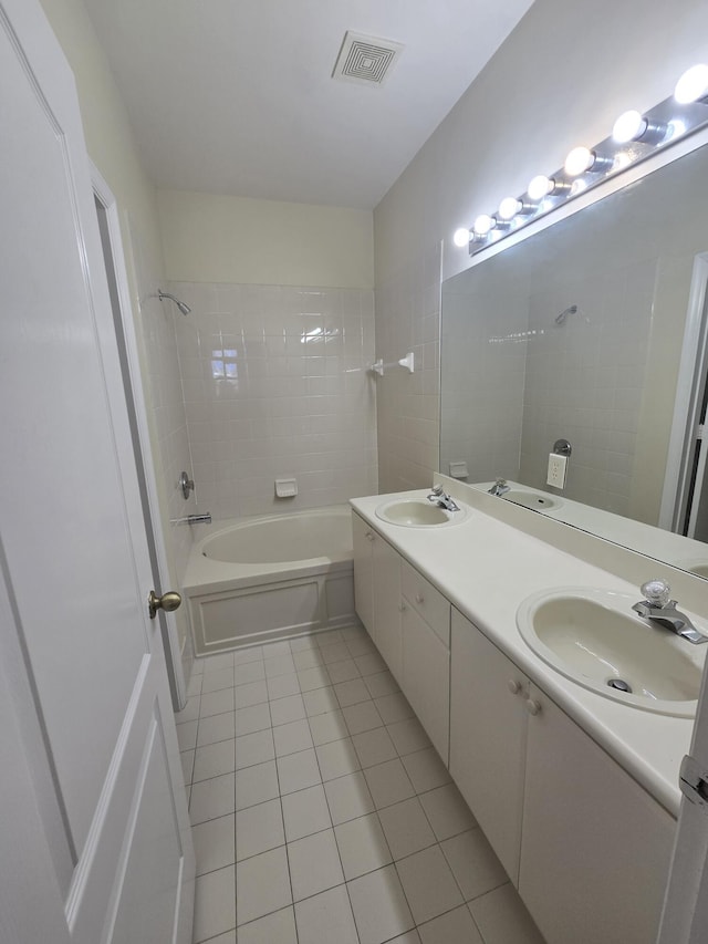 bathroom featuring tile patterned flooring, vanity, and tiled shower / bath