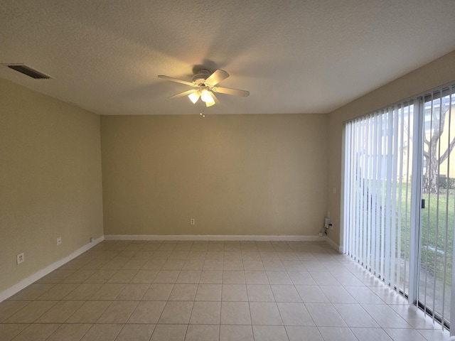 empty room with ceiling fan, a textured ceiling, and light tile patterned floors