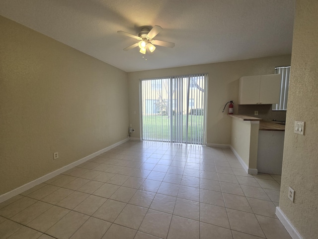 empty room with light tile patterned flooring and ceiling fan