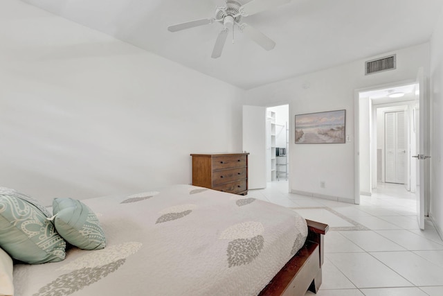 bedroom with light tile patterned flooring, ensuite bathroom, and ceiling fan