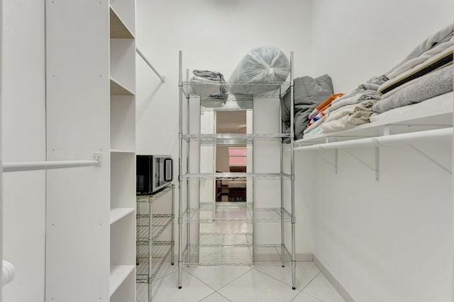 walk in closet with light tile patterned floors