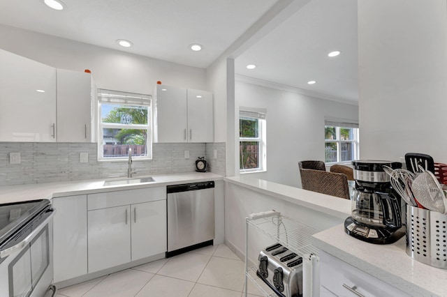 kitchen with sink, decorative backsplash, white cabinets, and appliances with stainless steel finishes