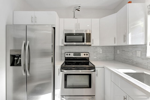 kitchen with tasteful backsplash, sink, stainless steel appliances, and white cabinets