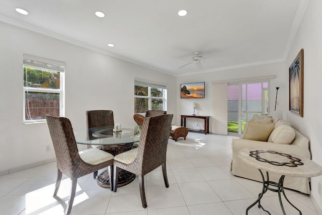 tiled dining space featuring ornamental molding and ceiling fan