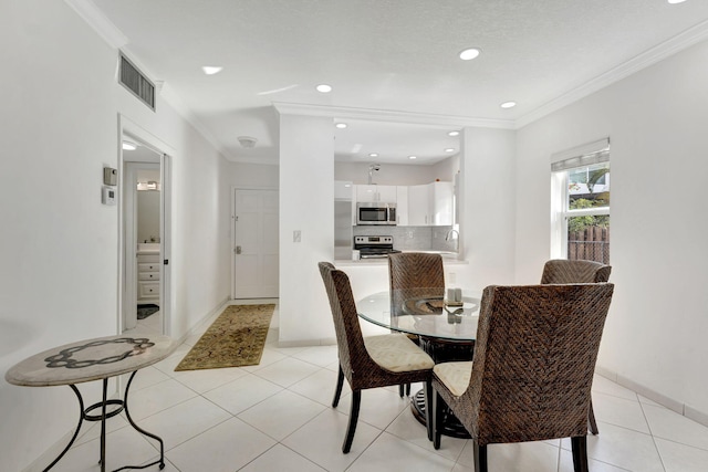 dining area featuring light tile patterned floors, crown molding, and sink