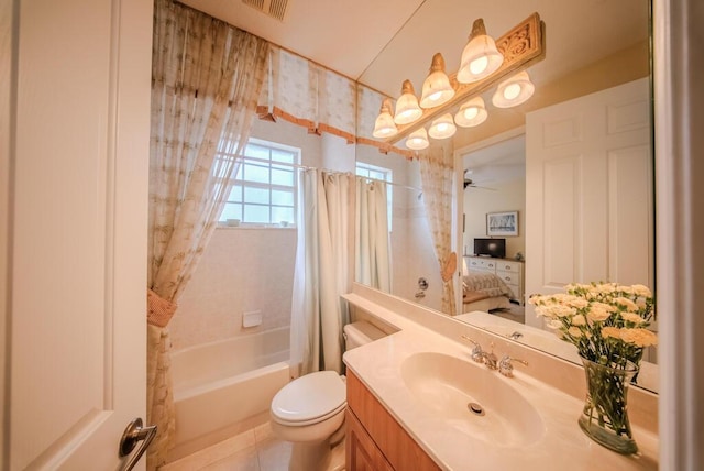 full bathroom with tile patterned floors, toilet, vanity, shower / bath combo with shower curtain, and ceiling fan