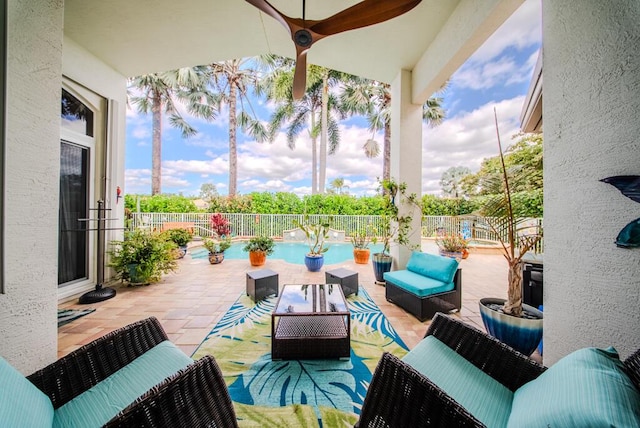 view of patio / terrace featuring ceiling fan, an outdoor living space, and a fenced in pool