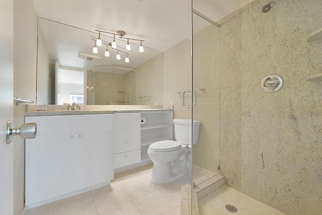 bathroom with vanity, tile patterned flooring, toilet, and walk in shower