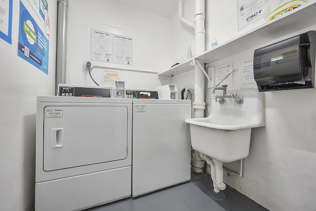 clothes washing area with washing machine and clothes dryer and sink