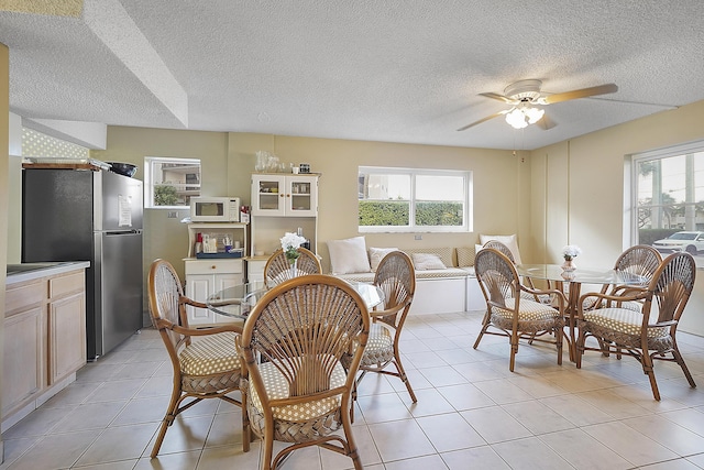 dining room with light tile patterned floors, a textured ceiling, and ceiling fan