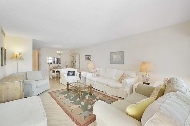 living room with light hardwood / wood-style flooring and a chandelier