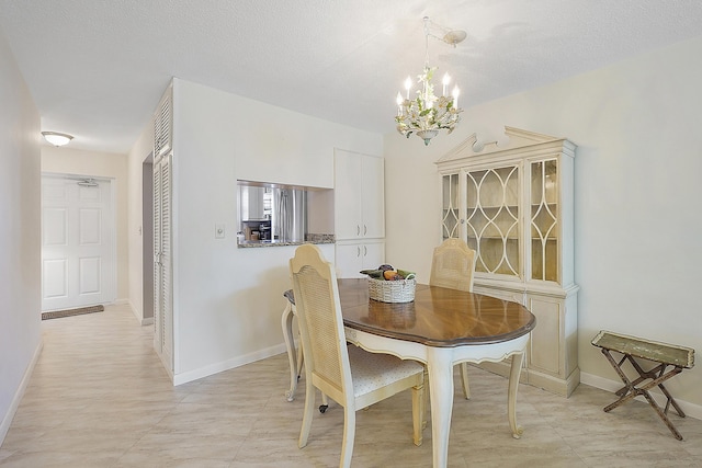 dining room featuring a chandelier and a textured ceiling