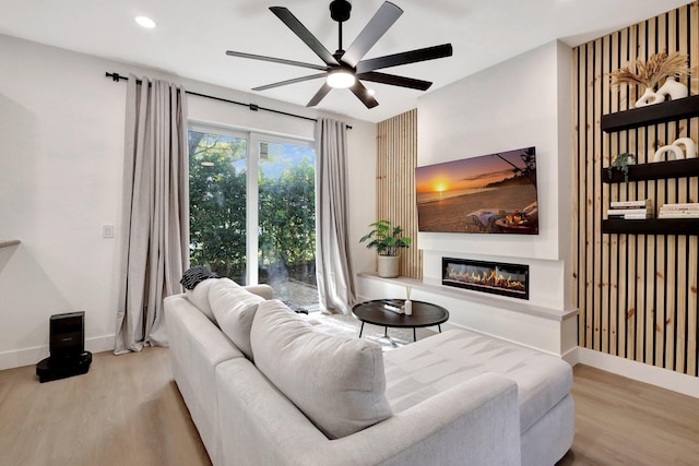 living room with light hardwood / wood-style floors and ceiling fan