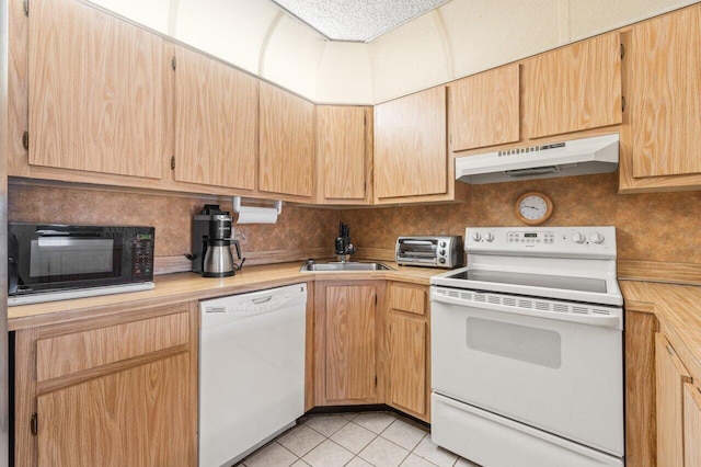 kitchen featuring light brown cabinetry, sink, tasteful backsplash, light tile patterned floors, and white appliances