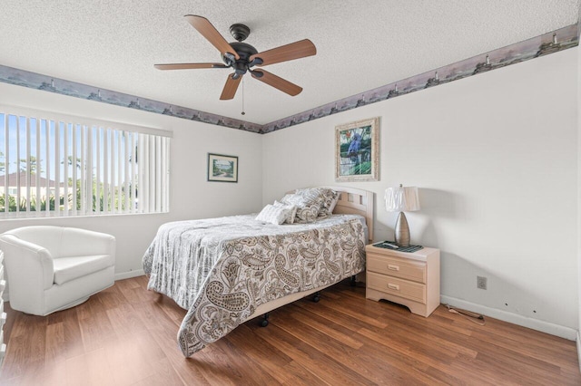 bedroom with ceiling fan, hardwood / wood-style flooring, and a textured ceiling