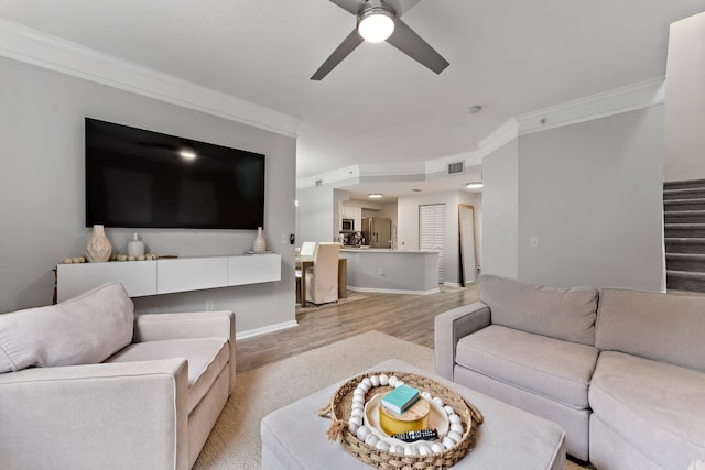 living room featuring ornamental molding, ceiling fan, and light hardwood / wood-style floors