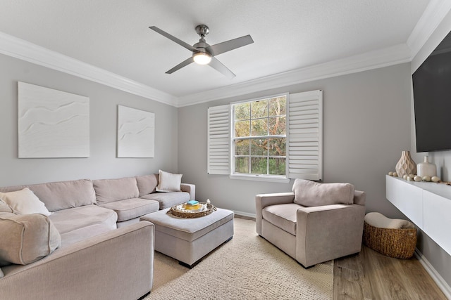 living room with ornamental molding, ceiling fan, and light wood-type flooring