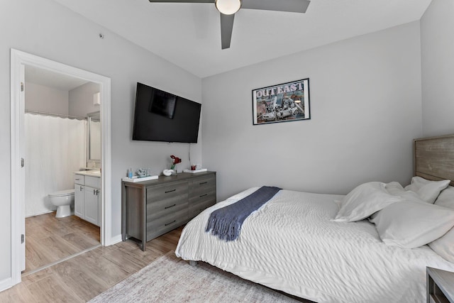 bedroom featuring light wood-type flooring, ceiling fan, and ensuite bathroom