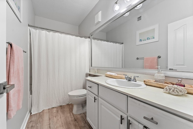 bathroom with vanity, hardwood / wood-style floors, a textured ceiling, and toilet