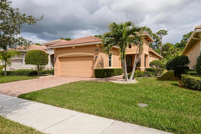 mediterranean / spanish house featuring a garage and a front lawn