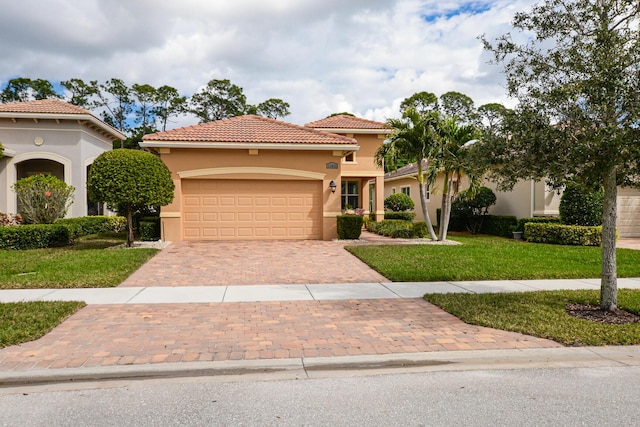 mediterranean / spanish-style home featuring a garage and a front lawn