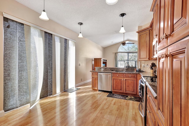 kitchen with pendant lighting, sink, tasteful backsplash, and appliances with stainless steel finishes