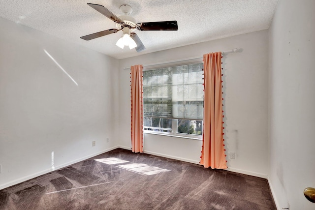 carpeted spare room with ceiling fan, a healthy amount of sunlight, and a textured ceiling