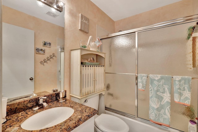 full bathroom with vanity, combined bath / shower with glass door, and toilet