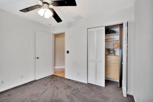 unfurnished bedroom featuring a textured ceiling, a closet, ceiling fan, and dark colored carpet