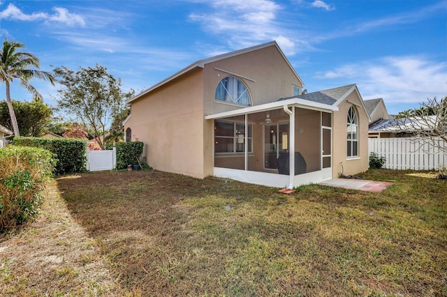 back of property featuring a yard and a sunroom