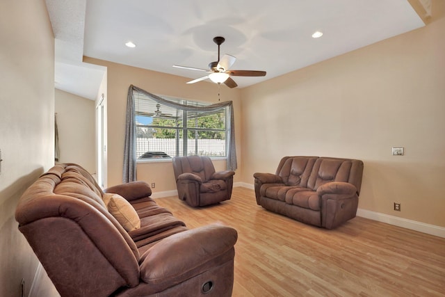 living room with light hardwood / wood-style flooring, ceiling fan, and vaulted ceiling