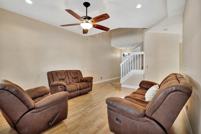 living room featuring ceiling fan, vaulted ceiling, and light hardwood / wood-style floors