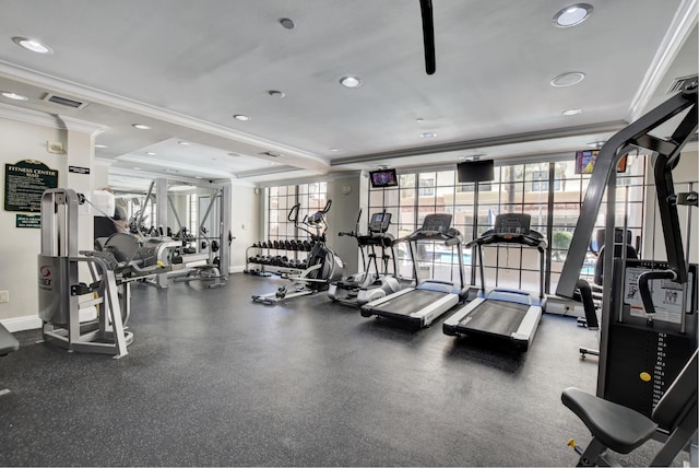 gym with ornamental molding and a raised ceiling