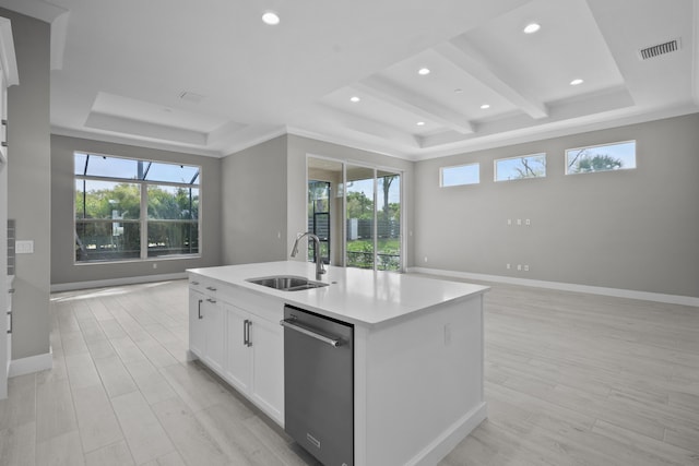 kitchen with sink, white cabinetry, a center island with sink, stainless steel dishwasher, and a raised ceiling