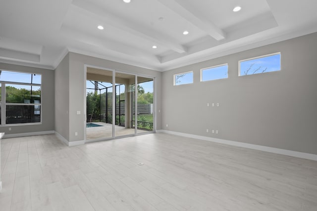 spare room with beamed ceiling, light hardwood / wood-style floors, and a tray ceiling