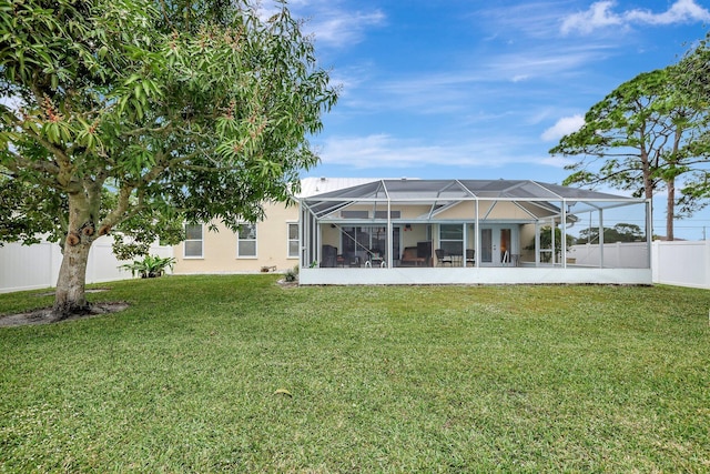 back of property featuring glass enclosure and a lawn