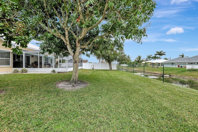 view of yard featuring a water view and a lanai