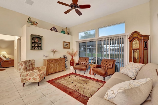 living room featuring a high ceiling, ceiling fan, and light tile patterned flooring