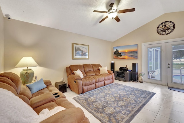 tiled living room with french doors, ceiling fan, lofted ceiling, and a textured ceiling