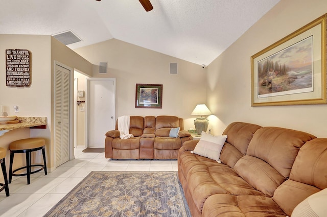 living room with lofted ceiling, ceiling fan, and light tile patterned flooring